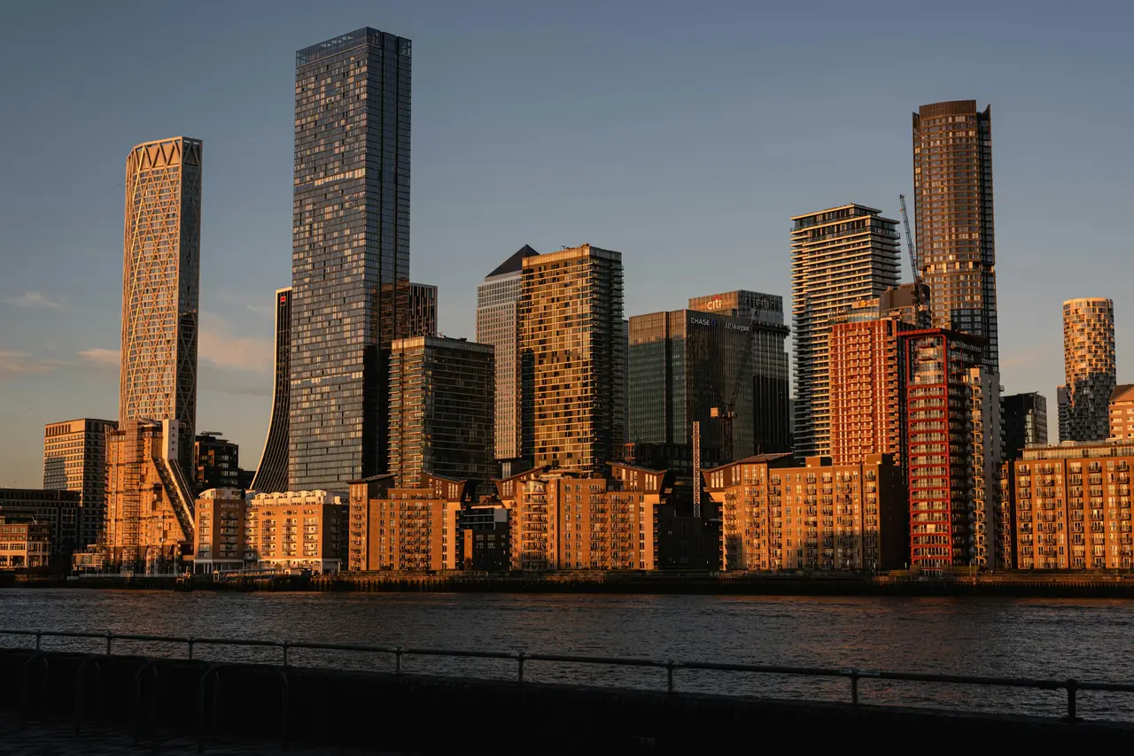 Torres de escritórios de Canary Wharf iluminadas pelo sol do fim de tarde, do outro lado do Tamisa
